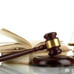 Golden scales of justice, gavel and books isolated on white